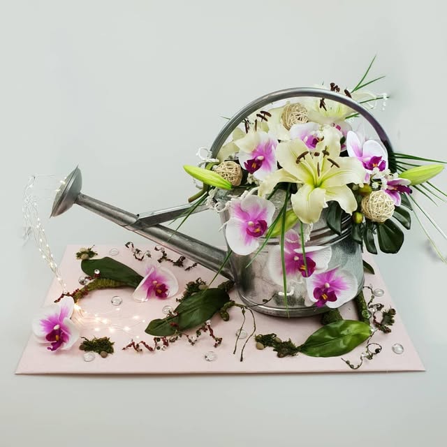 Bellissimo-Archiv: weiße Blüten und rosa Orchideen in einer dekorativen Gießkanne